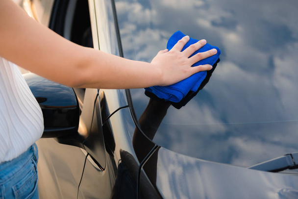 Primer plano retrato de la mujer de limpieza de la mano de vidrio del coche, Cuidado del coche
  - Foto, Imagen