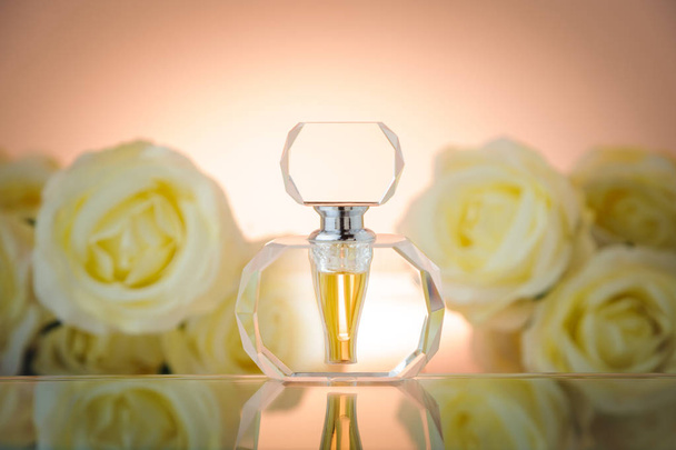 Skleněná lahvička na pozadí bílých růží - Fotografie, Obrázek