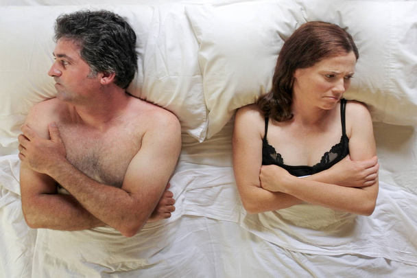 Παραπάνω άποψη του αναστατωμένος άνδρας και γυναίκα ξαπλωμένη στο κρεβάτι - Φωτογραφία, εικόνα