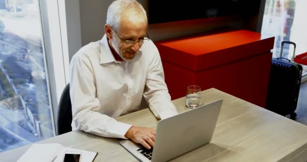 Mature businessman using laptop in hotel room 4k - Кадры, видео