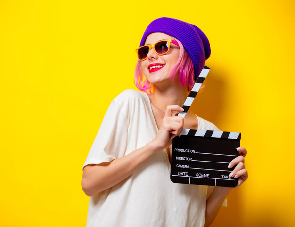 menina com cabelo rosa segurando filme palmas
 - Foto, Imagem