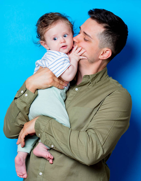 Young father and son on blue background - Photo, Image