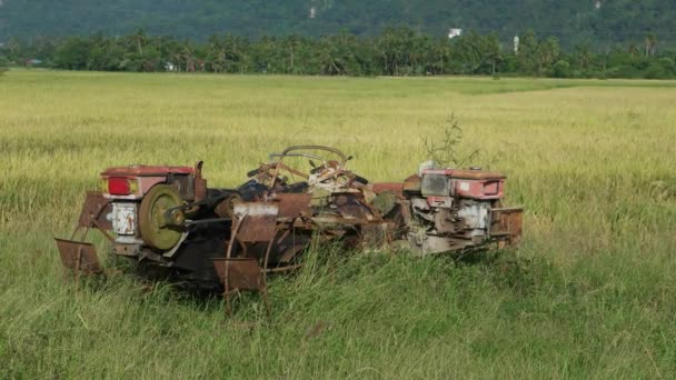 Elhagyott rozsdás rizshántoló traktor gép a nyílt terepen. - Felvétel, videó