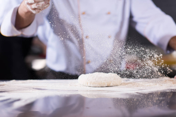 chef hands preparing dough for pizza on table sprinkled with flour closeup - Foto, immagini