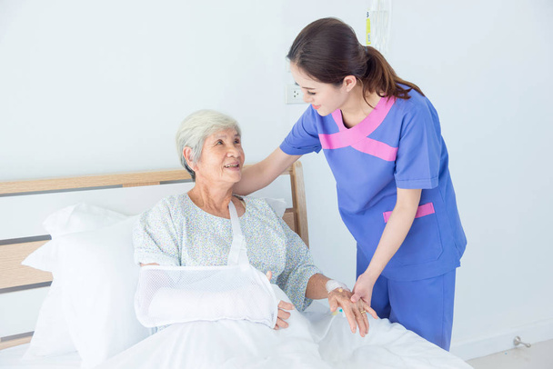 Seniorin lächelt mit Krankenschwester  - Foto, Bild
