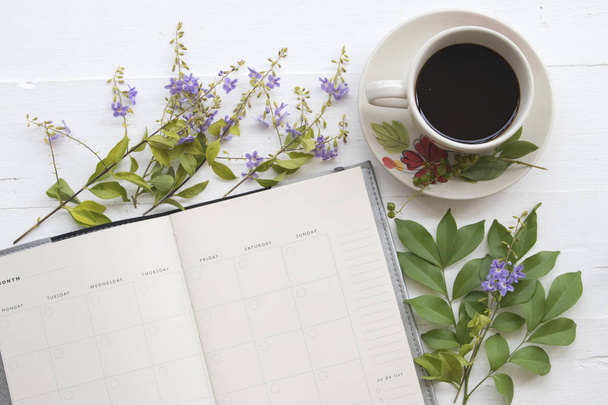 Popularne napoje gorące, świeże kawy palonej i planista notebook dla biznesu fioletowe kwiaty na białym tle - Zdjęcie, obraz