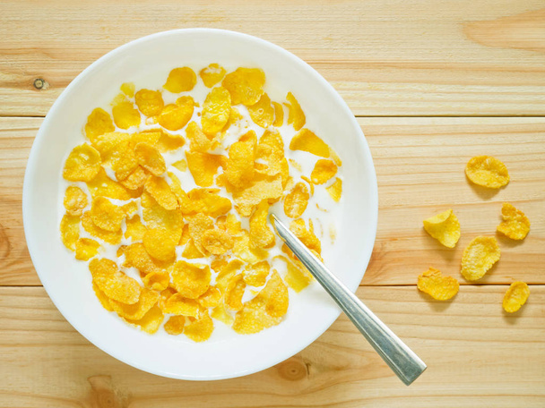 Golden cornflakes cereal on wooden table  - Photo, Image