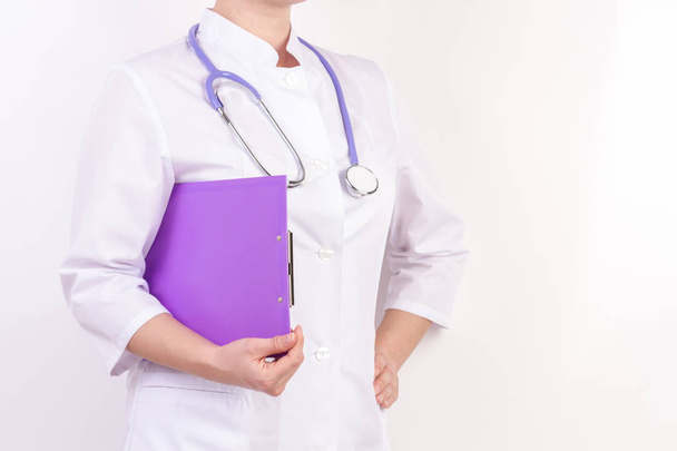 Doctor in white robe with stethoscope, with folder in hand, on white isolated background. - Foto, immagini