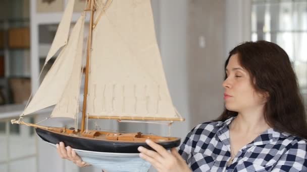 幸せな若い女は帆船の模型を持っています。 - 映像、動画