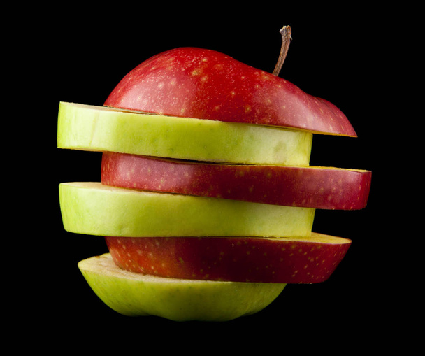 manzana roja y verde cortada sobre fondo negro
 - Foto, Imagen