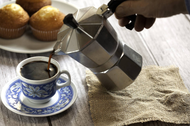 コーヒーとマフィンのカップ - 写真・画像
