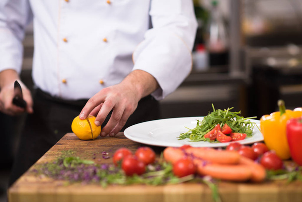 chef serving vegetable salad on plate in restaurant kitchen - Photo, image