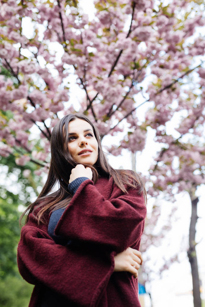 Spring beauty girl outdoors. Blooming sakura tree. Romantic young woman portrait - Foto, immagini