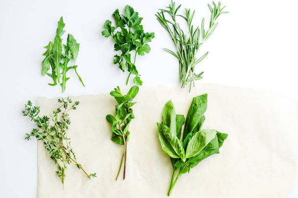 Fresh culinary herbs on white background: rosemary, thyme, mint, arugula, basil and parsley in small bunches - Фото, зображення