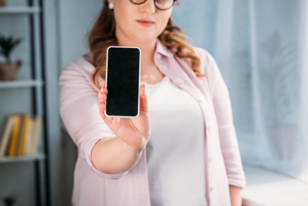cropped image of woman showing smartphone at home - Foto, immagini