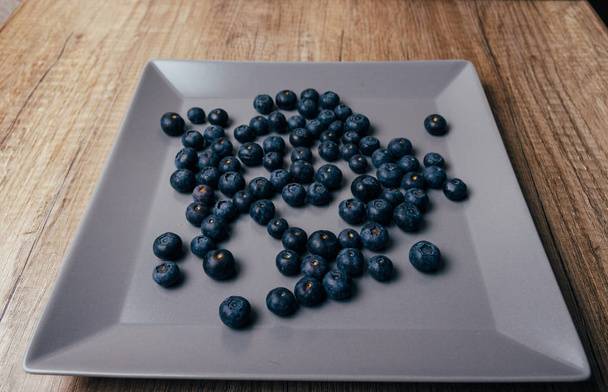 large, fresh blueberries lie on a gray plate, close-up - Photo, image