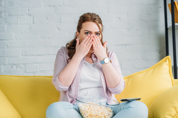 shocked beautiful woman watching movie with popcorn at home - Photo, image