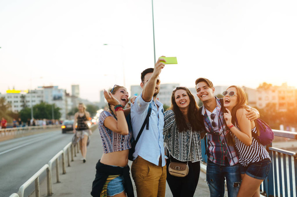 Happy young friends taking group selfie on street - Foto, imagen