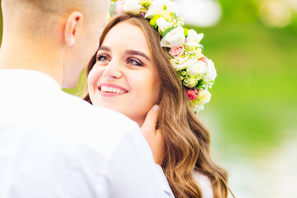 a sincere glance of a girl with a wreath on her head on her beloved boyfriend - Foto, Imagen