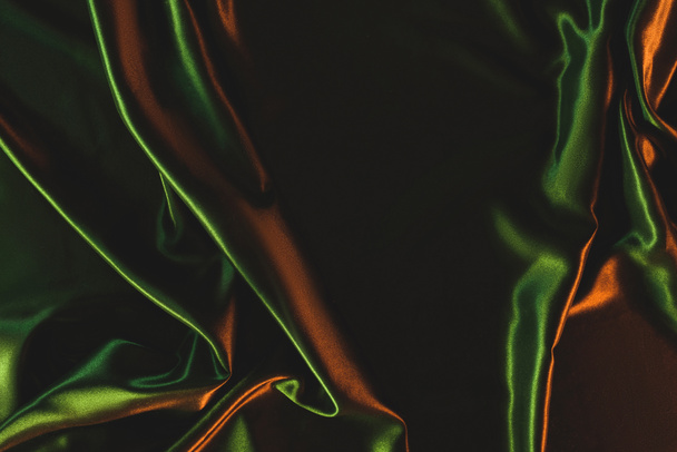 Close-up van donkere groene verfrommeld zijden doek als achtergrond - Foto, afbeelding