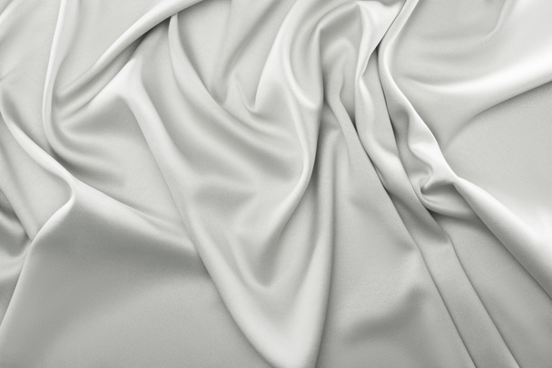 zblízka pohled skládané šedou hedvábné tkaniny jako pozadí - Fotografie, Obrázek