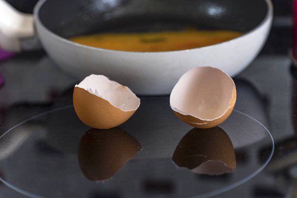Casca de ovo quebrada no forno preto e fundo de ovo não cozido
 - Foto, Imagem