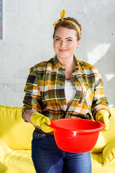 beautiful woman holding red bucket with water for cleaning at home - Фото, зображення
