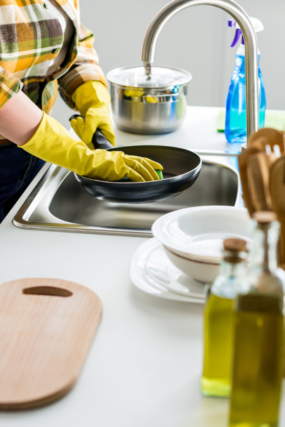 imagen recortada de mujer lavando sartén en la cocina
 - Foto, Imagen