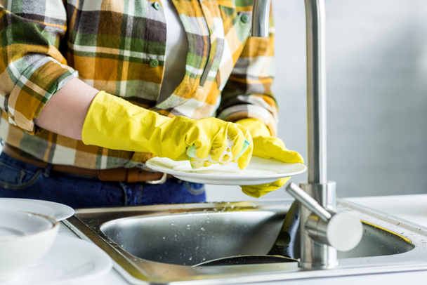 bijgesneden afbeelding van vrouw wassen plaat in keuken - Foto, afbeelding