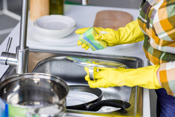 immagine ritagliata di donna che lava piatti in cucina
 - Foto, immagini