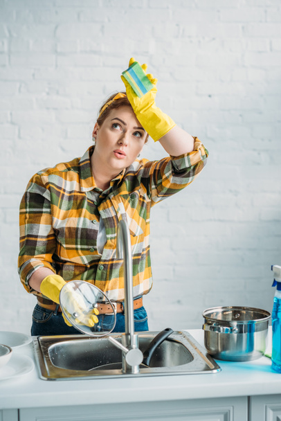 beautiful tired woman washing dishes at kitchen - Valokuva, kuva
