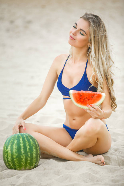 Młoda atrakcyjna kobieta na plaży relaksujące. Ładna kobieta z arbuza. Ładna dziewczyna na zewnątrz - Zdjęcie, obraz