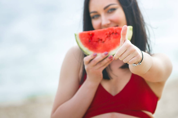 Young attractive woman on the beach relaxing. Pretty woman with watermelon. Cute girl outdoors - Foto, Imagen