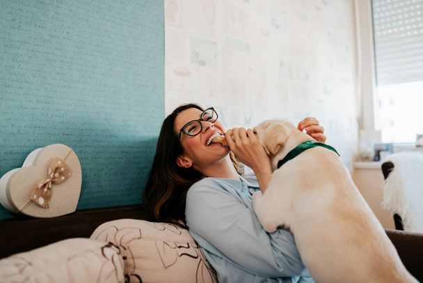 Woman having fun at her apartment with her dog. - Foto, Bild
