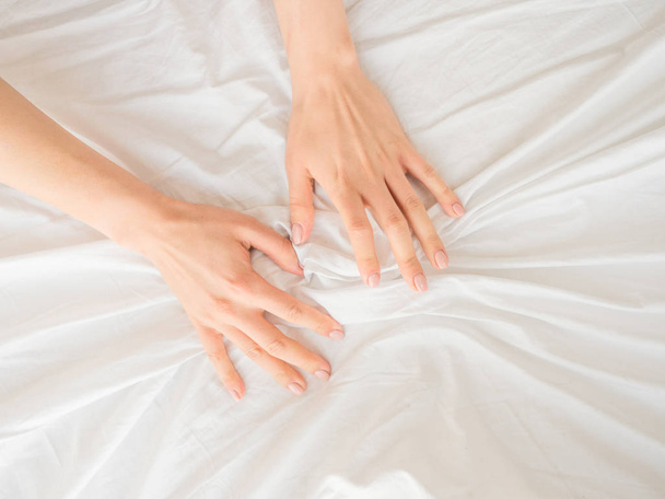 Female hands on a white bed sheets - Foto, Imagem
