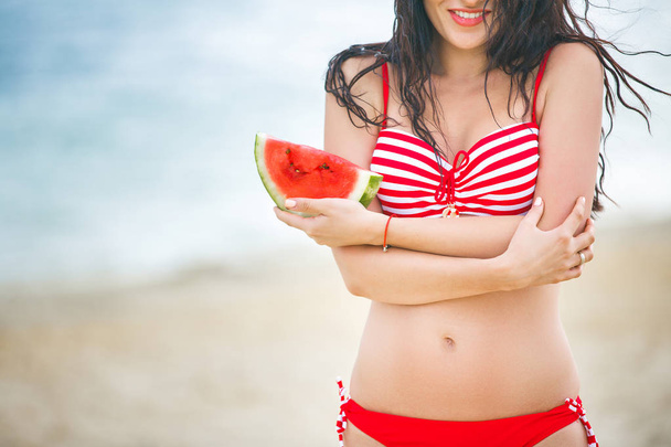 Nuori viehättävä nainen rannalla rentouttava. Kaunis nainen vesimelonin kanssa. Söpö tyttö ulkona
 - Valokuva, kuva