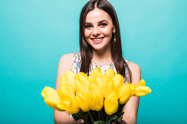 Szczęśliwa dziewczyna z żółtych tulipanów na niebieskim tle - Zdjęcie, obraz