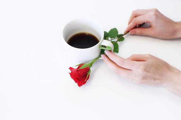 A hot cup of coffee and red rose on wooden table. Seasonal, morning coffee, Sunday relax and still life concept. Free place for text.Food concept. - 写真・画像