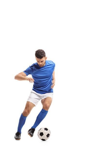 Full length portrait of a soccer player dribbling isolated on white background - Foto, afbeelding