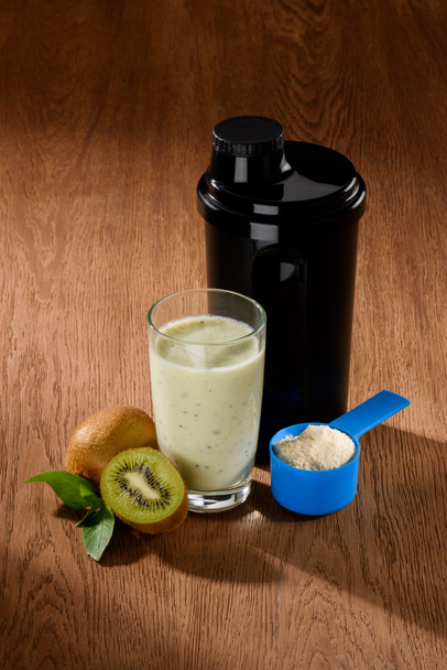 close-up shot of protein shake with kiwi on wooden surface - Photo, Image