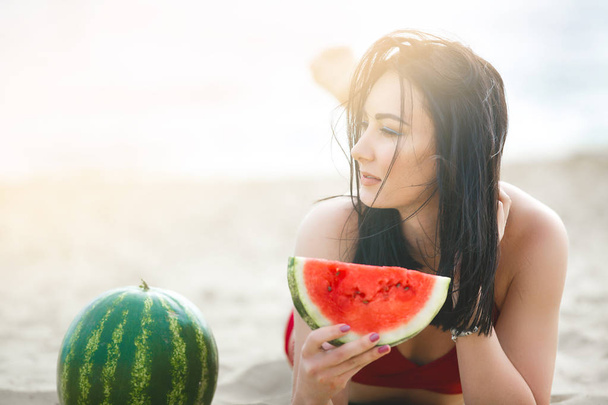 Jonge aantrekkelijke vrouw op het strand ontspannen. Mooie vrouw met watermeloen. Schattig meisje buiten - Foto, afbeelding