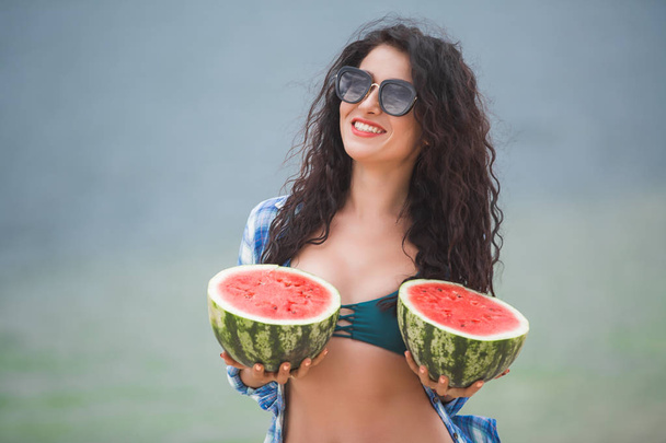 Young attractive woman on the beach with watermelon - Foto, imagen