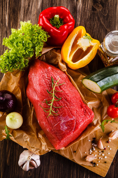Fresh raw beef on cutting board and vegetables - Foto, Imagen