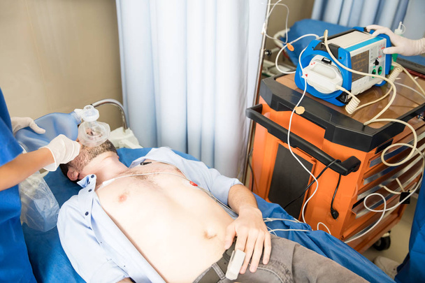 Mužského pacienta v bezvědomí na ventilátor v nemocniční ambulanci - Fotografie, Obrázek