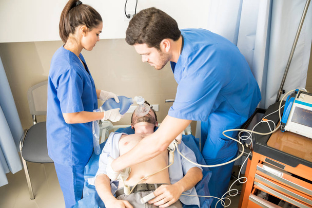 Deux médecins faisant une réanimation cardiopulmonaire avec un défibrillateur en salle d'urgence à l'hôpital
 - Photo, image