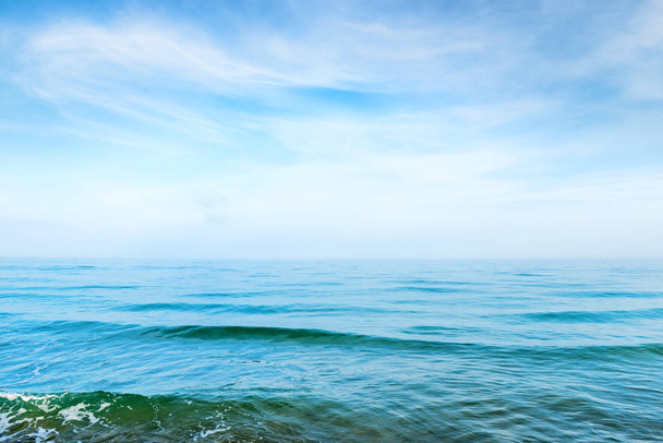 Синя морська вода з хвилями і білими хмарами на небі
 - Фото, зображення