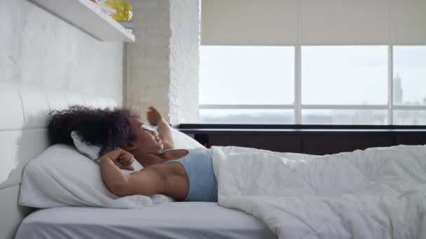 Güzel genç Afro-Amerikan kadın yatakta up uyanma - Video, Çekim
