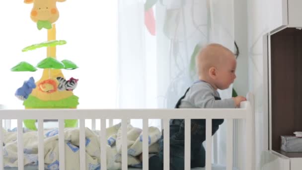 Sad baby boy, crying in crib at home - Кадры, видео