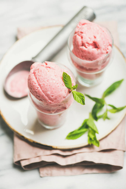 Healthy low calorie summer dessert. Homemade strawberry yogurt ice cream in glasses over light grey marble table background - Фото, изображение