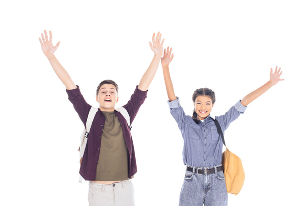retrato de adolescentes excitados con mochilas extendiendo los brazos aislados en blanco
 - Foto, Imagen